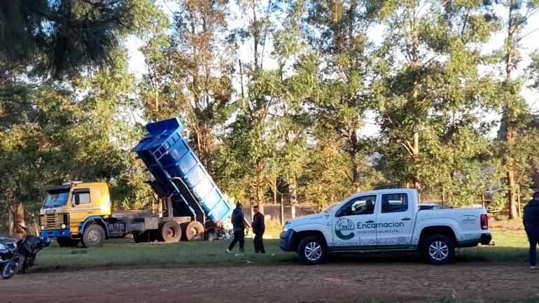 Máquina municipal arrojando basura en sitio no habilitado.