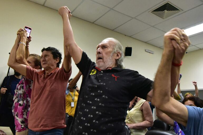 Víctimas de la tortura Luis Casco y Carlos Casco celebran la sentencia del comisario de policía retirado Eusebio Torres por la tortura de víctimas de la dictadura del general Alfredo Stroessner (1954-1989) en el Palacio de Justicia de Asunción en febrero 20 de septiembre de 2024. El comisario de policía retirado Eusebio Torres Romero fue sentenciado a 30 años de prisión por torturar a dos hermanos y a la esposa de uno de ellos durante la dictadura del general Alfredo Stroessner en Paraguay, según un fallo judicial publicado el martes. (Foto de NORBERTO DUARTE/AFP)