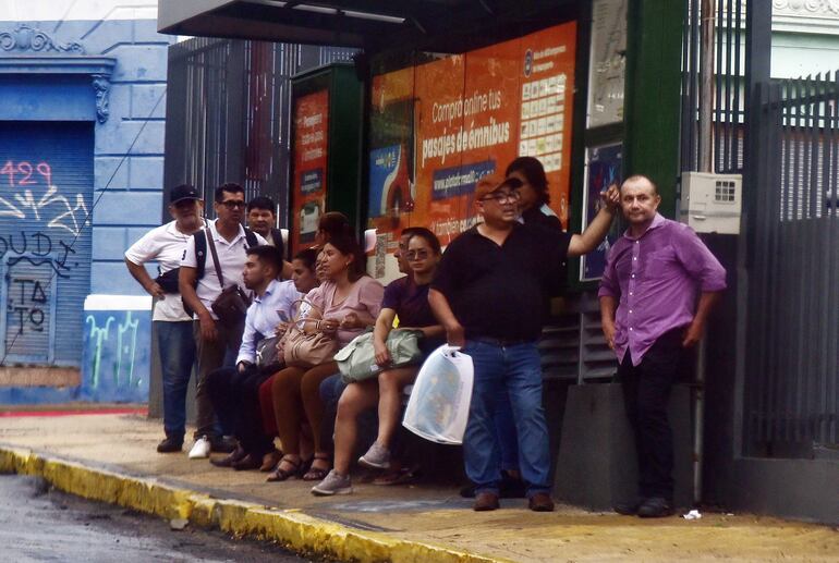 Pasajeros se enciman en las pocas paradas con refugios para resguardarse de las lluvias.