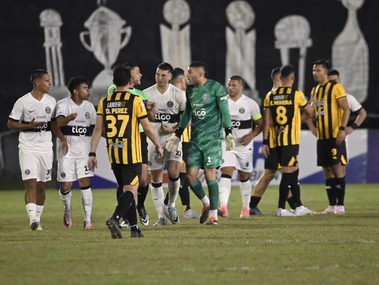 Los jugadores de Olimpia reclaman al árbitro Blas Romero por el penal sancionado después de una mano de Junior Barreto en el partido contra Guaraní por la primera fecha del torneo Clausura 2024 del fútbol paraguayo en el estadio Antonio Aranda, en Ciudad del este.