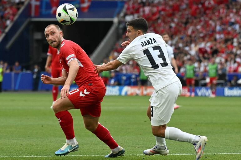 Denmark's midfielder #10 Christian Eriksen and Slovenia's defender #13 Erik Janza fights for the ball during the UEFA Euro 2024 Group C football match between Slovenia and Denmark at the Stuttgart Arena in Stuttgart on June 16, 2024. (Photo by THOMAS KIENZLE / AFP)