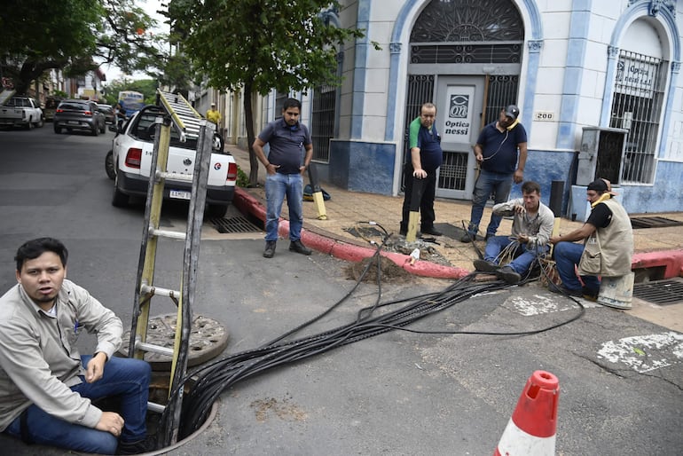 Técnicos de  Copaco a cargo de Alberto Martínez (izq.) trabajan para restablecer las líneas cortadas del centro de distribución ubicado en Yegros esquina Herrera. Es una tarea de todos los días y según los datos, el 95% de los robos de cables son perpetrado por los "chespis".