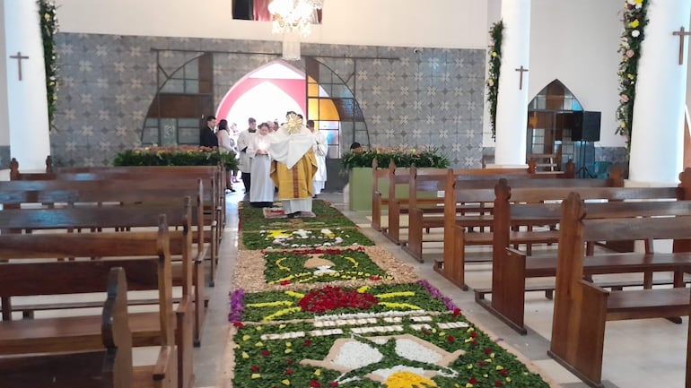 Momento en que el Santísimo Sacramento ingresa al templo de San Antonio adornado con alfombra de flores, por el día de Corpus Christi.