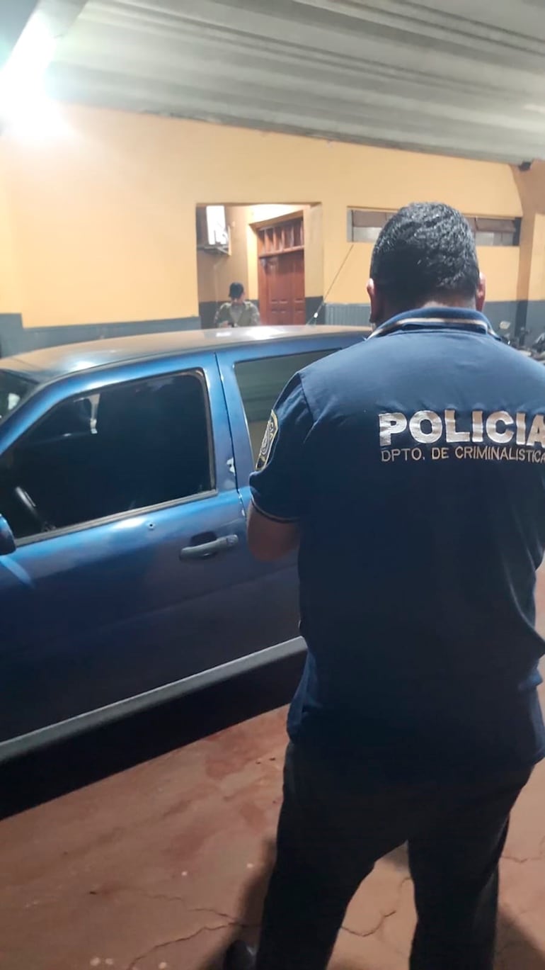 Agentes de Criminalística verifican los impactos de bala encontrados en el auto.