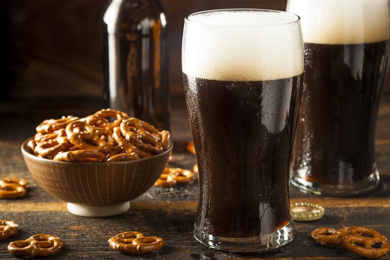 Dos pintas de cerveza negra con pretzels, en la barra de un pub irlandés.