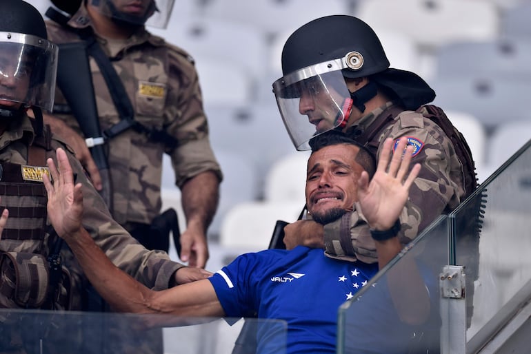 La policía antidisturbios detiene a un fanático del Cruzeiro de Brasil durante enfrentamientos en el partido de fútbol del Campeonato Brasileño contra Palmeiras, en Belo Horizonte, Brasil.