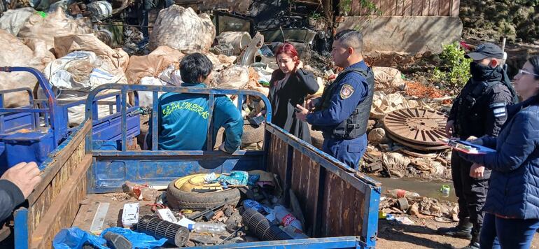 Con acompañamiento policial, funcionarios municipales buscan a responsables de arrojar basura en el atracadero de Remansito.