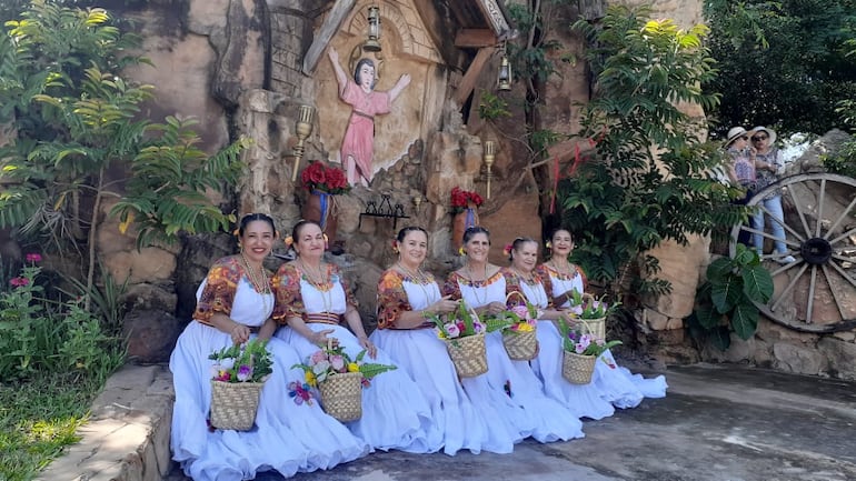 Los visitantes se toman fotografías frente al santo Divino Niño Jesús que se encuentra dentro del predio de la galería.