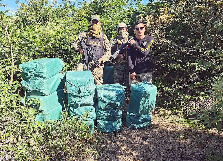 Oficiales de la Policía Nacional custodian el enorme cargamento de droga que encontraron en una parte de la estancia El Tigre.