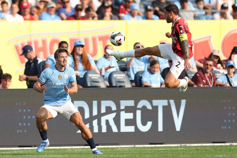 TOPSHOT - AC Milan's Italian defender #02 Davide Calabria (R) fights for the ball with Manchester City's English midfielder #10 Jack Grealish during the pre-season club friendly football match between Manchester City and AC Milan at Yankee Stadium in New York on July 27, 2024. (Photo by Charly TRIBALLEAU / AFP)