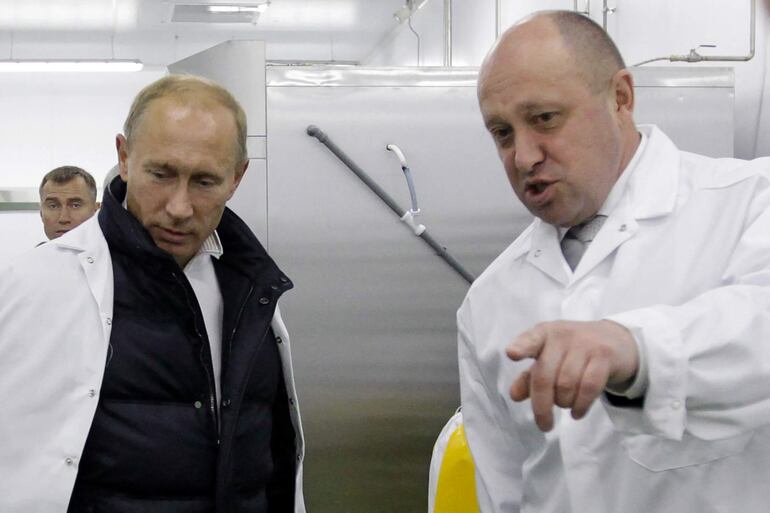 Fotografía captada en 2010 del líder del grupo paramilitar Wager, Yevgeny Prigozhin, junto al entonces primer ministro de Rusia, Vladimir Putin, en una escuela de San Petersburgo. (SPUTNIK/AFP)