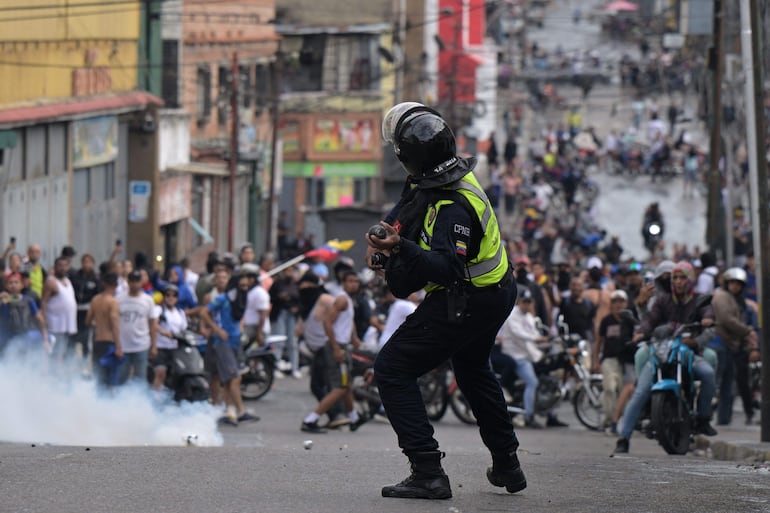 Caracas: un policía arroja gas lacrimógeno contra la multitud, 29 de julio de 2024 (Foto: Yuri Cortez / AFP)