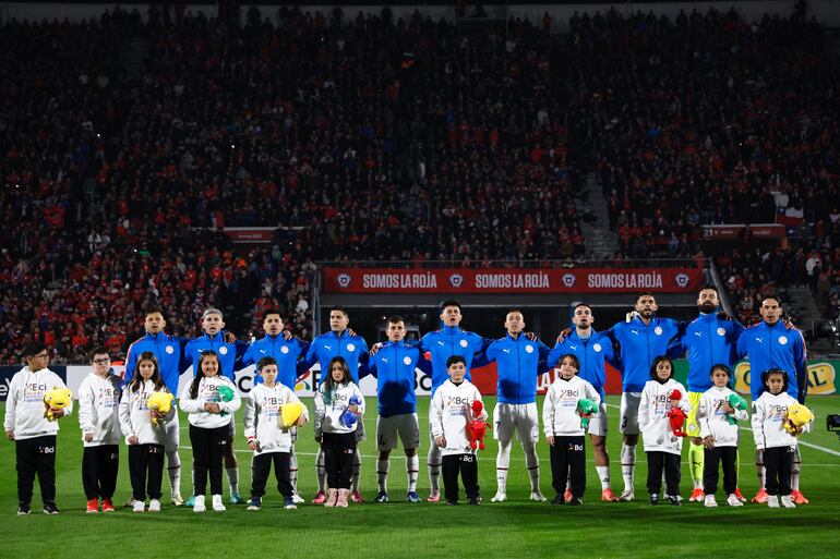 Los jugadores de la selección paraguaya entonan el himno nacional en la previa del amistoso internacional frente a Chile en el estadio Nacional, en Santiago, Chile.
