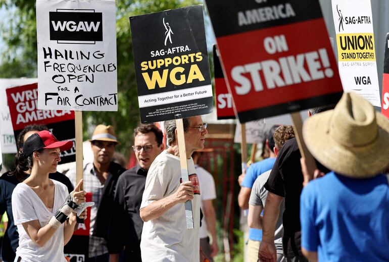 Un letrero dice 'SAG-AFTRA apoya a WGA' mientras los miembros de SAG-AFTRA caminan en la línea de piquete en solidaridad con los trabajadores en huelga de WGA (Writers Guild of America) frente a las oficinas de Netflix el 13 de julio de 2023 en Los Ángeles , California.