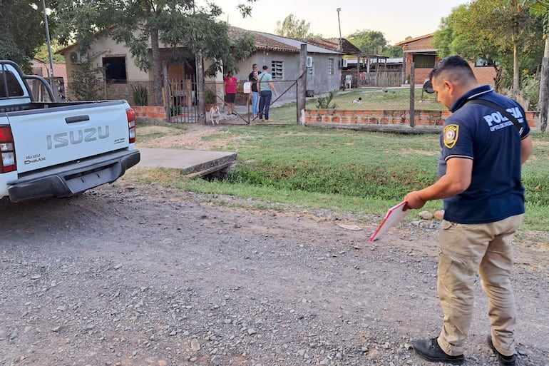 Un policía de Investigaciones de Presidente Hayes recoge evidencia frente a la casa de su compañera, la suboficial segundo Marian Castillo Barrios, en la ciudad de Benjamín Aceval.