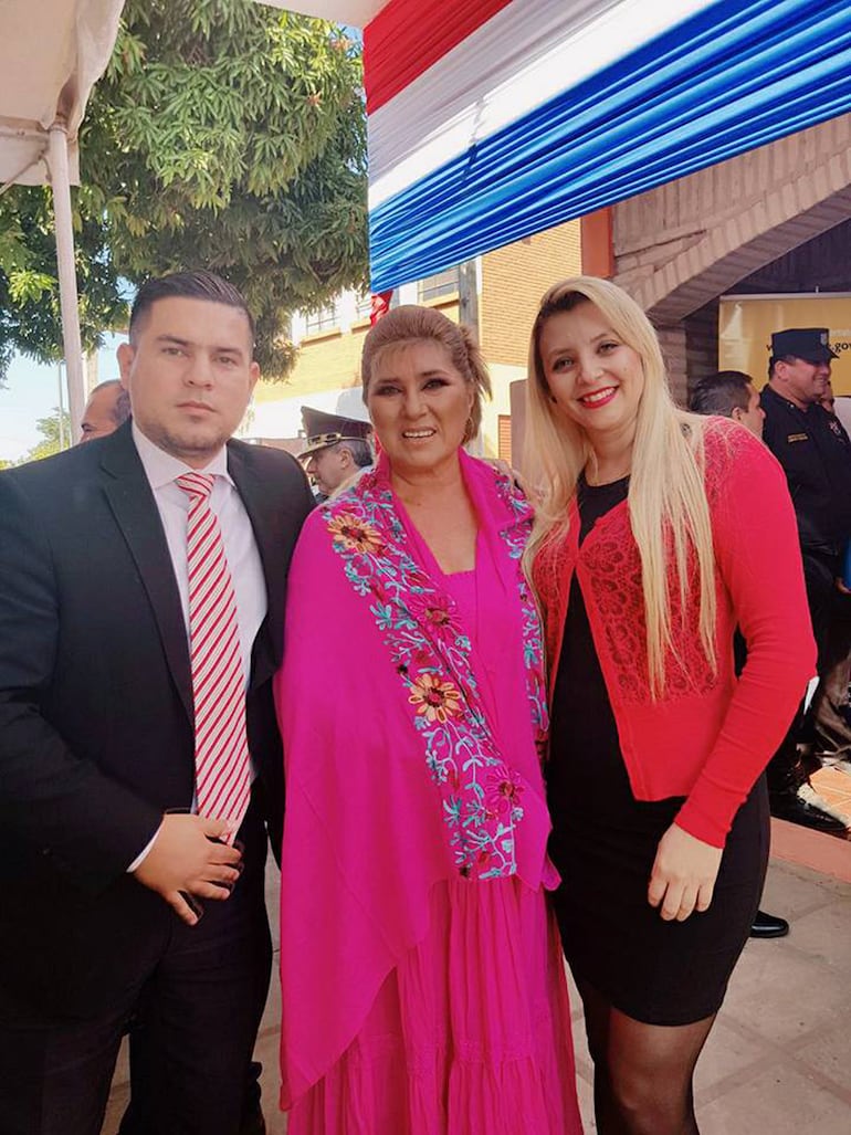 María Lidia (centro) luciendo un lindo vestido de color fucsia, en compañía de otras personas. 