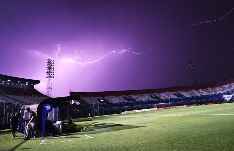 El destello eléctrico de un rayo se observa de fondo en el estadio Defensores del Chaco. (Imagen de referencia).