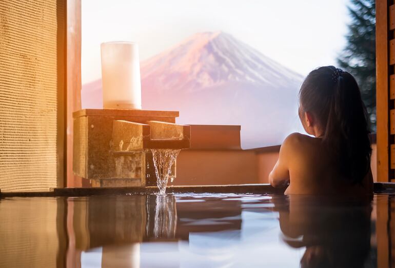 Mujer en un baño onsen con vistas al Monte Fuji. Foto SAHACHATZ/Shutterstock, facilitada por Journalistic.org. /EFE
