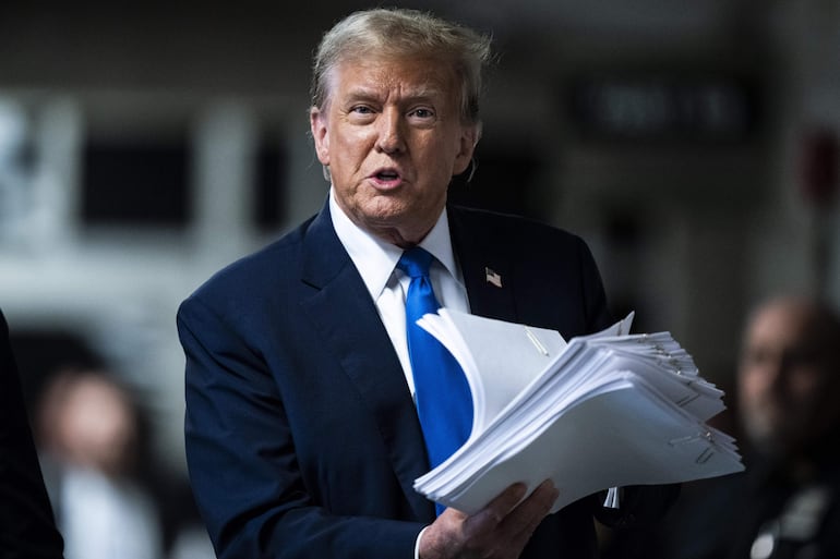 Fotografía de archivo del expresidente de los Estados Unidos Donald Trump con documentos a su salida de una audiencia en una corte de Manhattan en Nueva York (EE.UU.). 