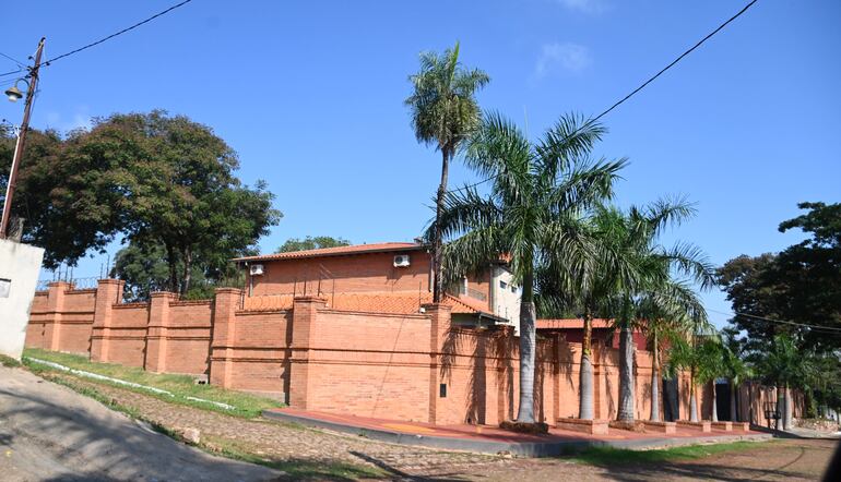 Muralla de casi tres metros de ladrillo con terminación vista rodea la casa ubicada en una esquina.