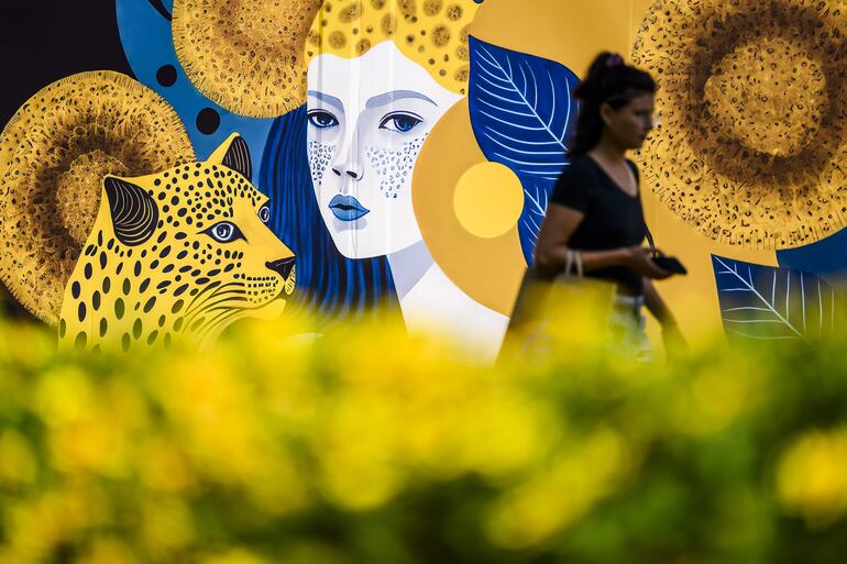 Una mujer camina frente al logotipo del festival.