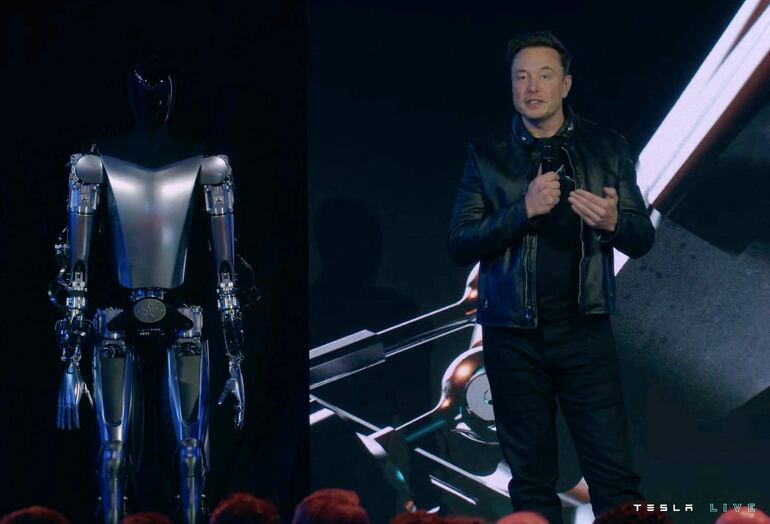 En esta foto de 2022 se ve a Elon Musk junto al robot humanoide Optimus. 