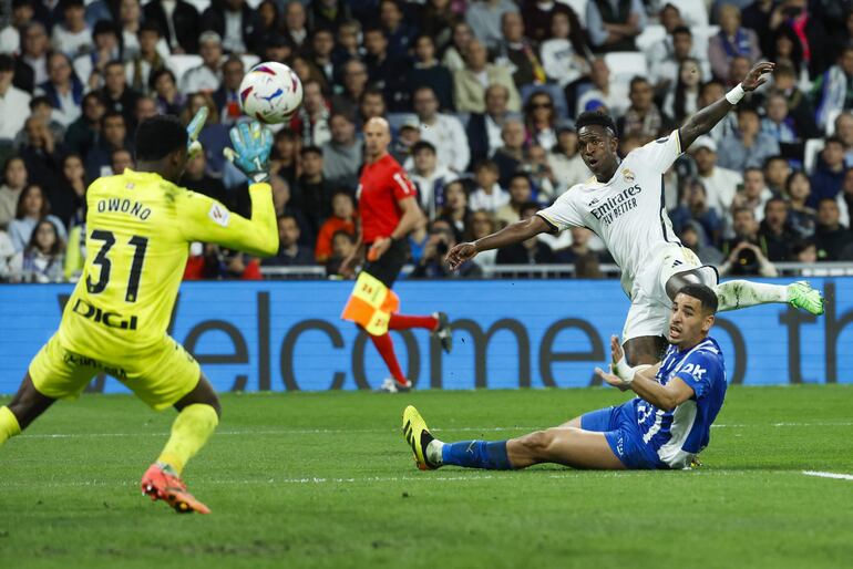 MADRID, 14/05/2024.- El delantero del Real Madrid Vinicius Junior (d, arriba) chuta para marcar el cuarto gol ante el Alavés, durante el partido de Liga en Primera División que Real Madrid y Deportivo Alavés disputan este martes en el estadio Santiago Bernabéu. EFE/Juanjo Martín
