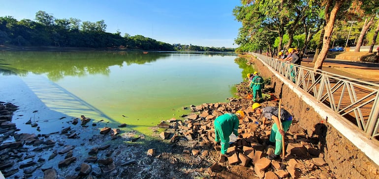 Operarios de una empresa contratada por la Itaipú limpian la zona del dique. 