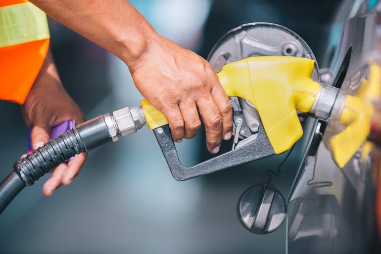 Una persona carga combustible en una estación de servicio.