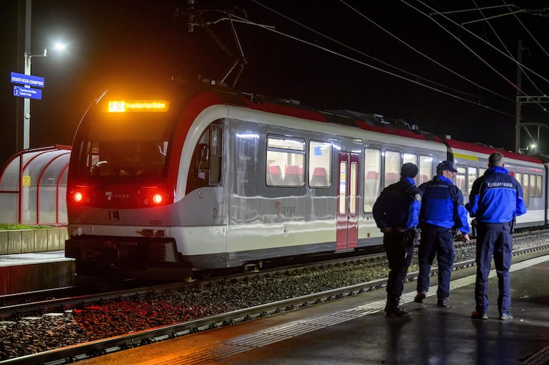 Policías junto al tren en el que se produjo la toma de rehenes, el jueves en Essert-sous Champvent, Suiza.