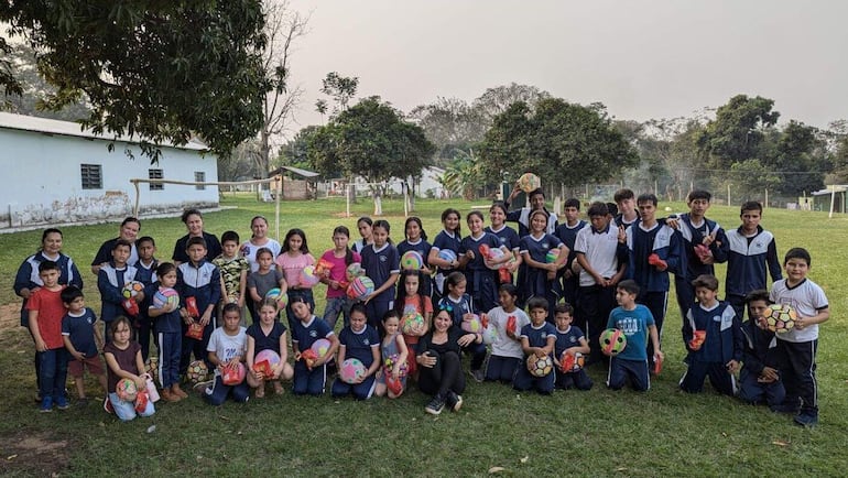 Los niños y niñas de una escuela exhiben con alegría  sus regalos que recibieron  en la misma institución