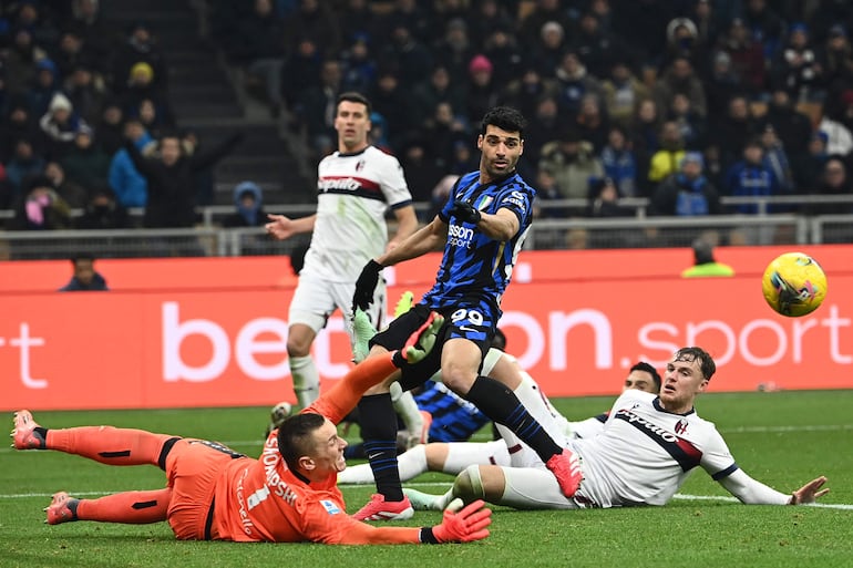 Bologna's Polish goalkeeper #01  Lukasz Skorupski (L) save the ball from a shot by Inter Milan's Iranian forward #99  Mehdi Taremi (C) during  the  Italian Serie A football match between Inter Milan and Bologna at the San Siro Stadium in Milan on January 15, 2025. (Photo by Isabella BONOTTO / AFP)