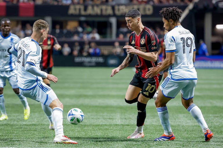 ATLANTA (United States), 23/02/2025.- Atlanta United midfielder Miguel Almiron (C) in action against CF Montreal midfielder Fabian Herbers (L) and CF Montreal midfielder Nathan-Dylan Saliba (R) during the first half of a MLS soccer match between CF Montreal and Atlanta United in Atlanta, Georgia, USA, 22 February 2025. EFE/EPA/ERIK S. LESSER
