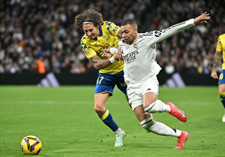 Real Madrid's French forward #09 Kylian Mbappe fights for the ball with Las Palmas' Portuguese forward #37 Fabio Silva during Spanish league football match between Real Madrid CF and UD Las Palmas at the Santiago Bernabeu stadium in Madrid on January 19, 2025. (Photo by JAVIER SORIANO / AFP)