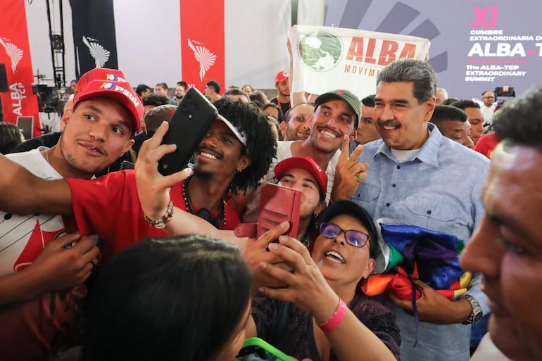 El presidente de Venezuela, Nicolás Maduro (d), posando con simpatizantes durante una cumbre virtual con jefes de Estado de la Alianza Bolivariana para los Pueblos de Nuestra América (ALBA), este lunes, en Caracas (Venezuela). rrencia sobre la controvertida reelección del líder chavista en los comicios del 28 de julio. EFE