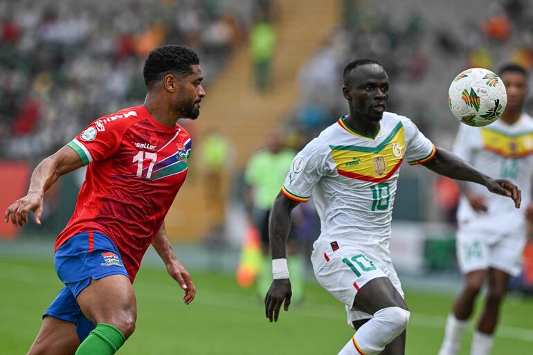 Sadio Mané (d), delantero de Senegal,  disputa el balón con Saidy Janko, zaguero de Gambia, durante el partido de ayer.