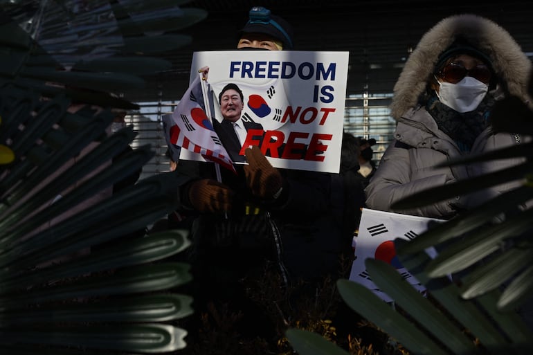 Seguidores del presidente Yoon Suk Yeol, de Corea del Sur, se manifiestan frente a su residencia para evitar sea arrestado.