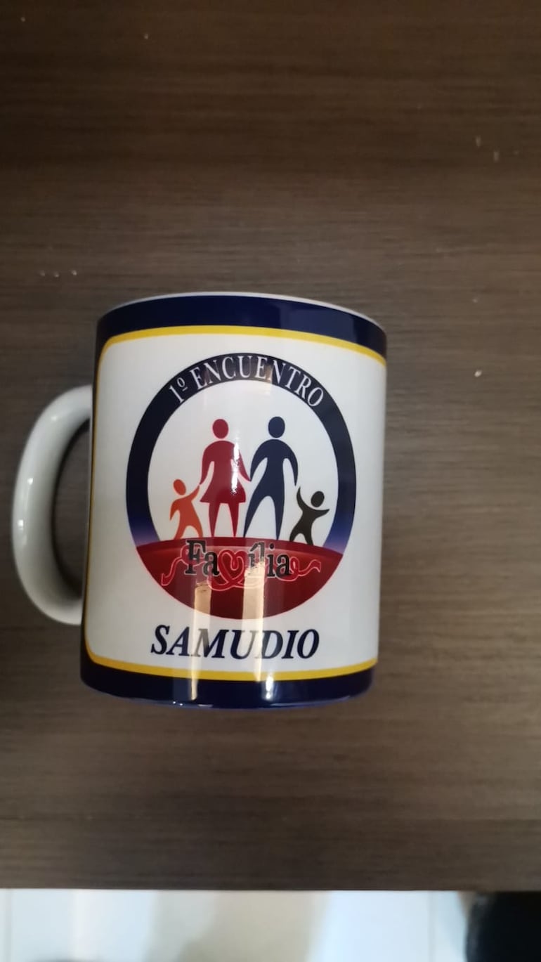 Una taza con la inscripción de una actividad y el apellido de Jorge Samudio.