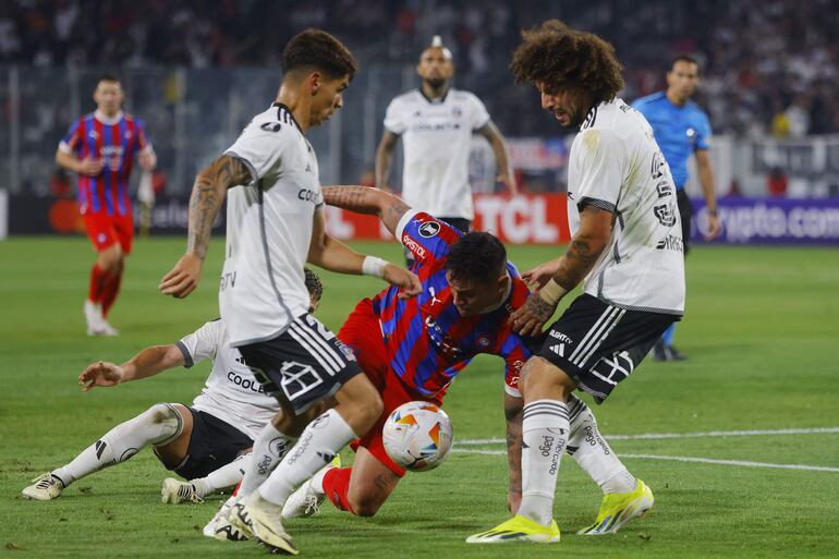 Maximiliano Falcón (d) de Colo Colo disputa el balón con Eduardo Nascimento (c) de Cerro este miércoles, en un partido de la fase de grupos de la Copa Libertadores entre Colo Colo y Cerro Porteño en el estadio Monumental en Santiago (Chile).