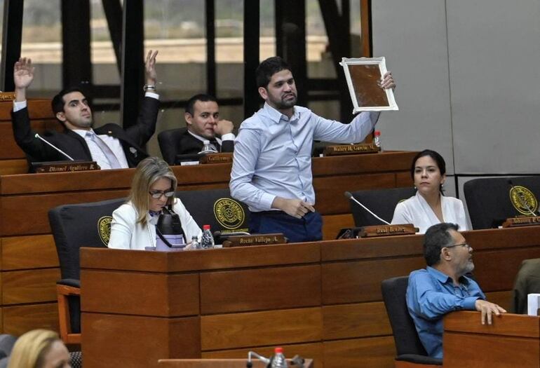 El diputado Raúl Benítez (Partido Encuentro Nacional) blande en alto un espejo durante la sesión en la que se discute la derogación del convenio con la Unión Europea. "Les recomiendo que se compren un espejo para ver si ahí no ven a los culpables del fracaso del sistema educativo", espetó a sus colegas.