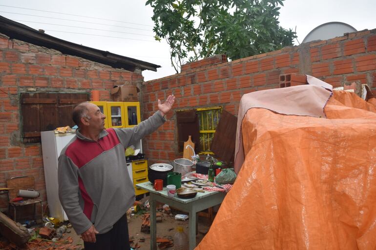 Don Benicio Ramírez, muestra como el viento se llevó esta madrugada parte del techo de su vivienda.