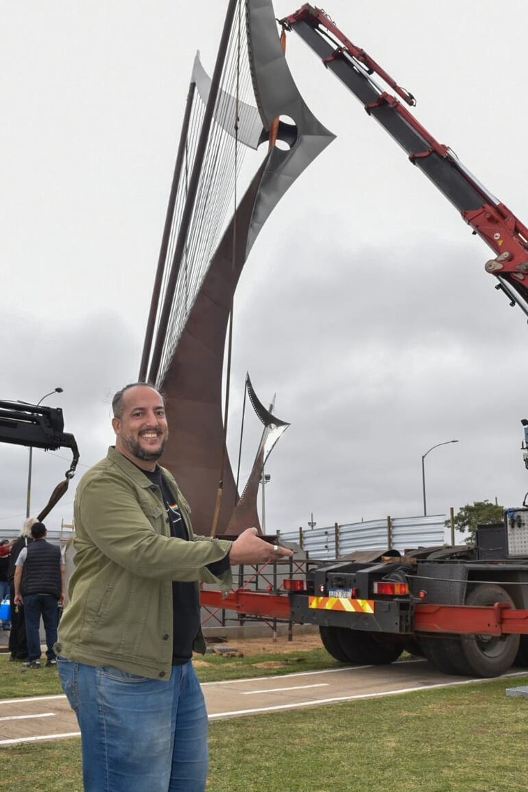 El arpista Juan Pablo Pistilli posa con su escultura, en homenaje al arpa paraguaya, durante el emplazamiento de la obra en la Costanera de Asunción.