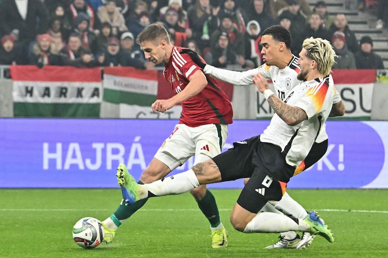 Hungary's forward #19 Barnabas Varga (L) gets a shot away but fails to score next to Germany's midfielder #10 Jamal Musiala and Germany's midfielder #08 Robert Andrich  during the UEFA Nations League Group C1 football match Sweden vs Azerbaijan at the Strawberry Arena in Solna, north of Stockholn, Sweden on November 19, 2024. (Photo by Attila KISBENEDEK / TT NEWS AGENCY / AFP) / Sweden OUT