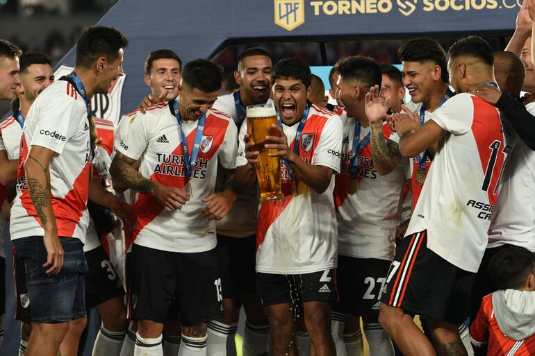 Robert Rojas y Héctor David Martínez festejan con el resto del plantel el título de campeón de Liga Profesional con River Plate.