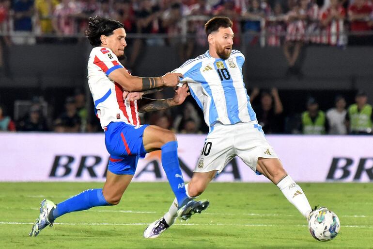 Gustavo Gómez (i), jugador de la selección de Paraguay, pelea por el balón con Lionel Messi, futbolista de Argentina, en el partido por la fecha 11 de las Eliminatorias Sudamericanas 2026 en el estadio Defensores del Chaco, en Asunción, Paraguay.