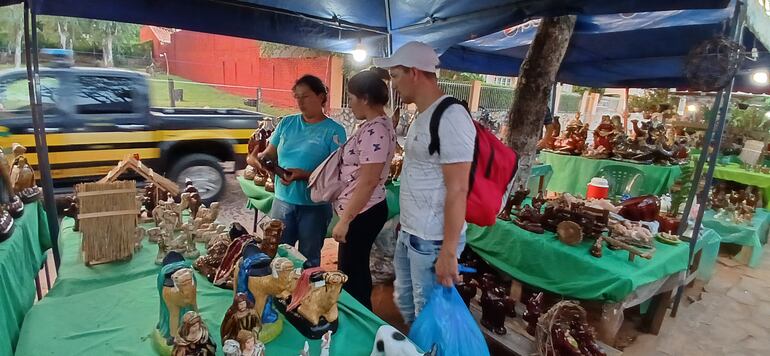 una vendedora de pesebres muestra a futuros compradores la variedad de sus productos