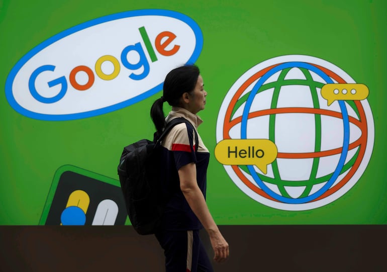 Una mujer frente a publicidad de Google en Shanghai (China). Google anunció este miércoles que ha “mejorado significativamente” la experiencia del usuario a la hora de generar imágenes “fotorrealistas” de personas mediante Gemini, su inteligencia artificial (IA), después de que se viralizaran las respuestas inexactas y sesgadas de su modelo anterior.