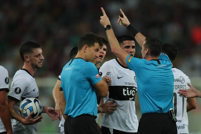 Los jugadores de Olimpia discuten con el árbitro uruguayo Andrés Matonte en el partido de ida de los cuartos de final de la Copa Libertadores 2023 contra Fluminense en el estadio Maracaná, en Río de Janeiro, Brasil.