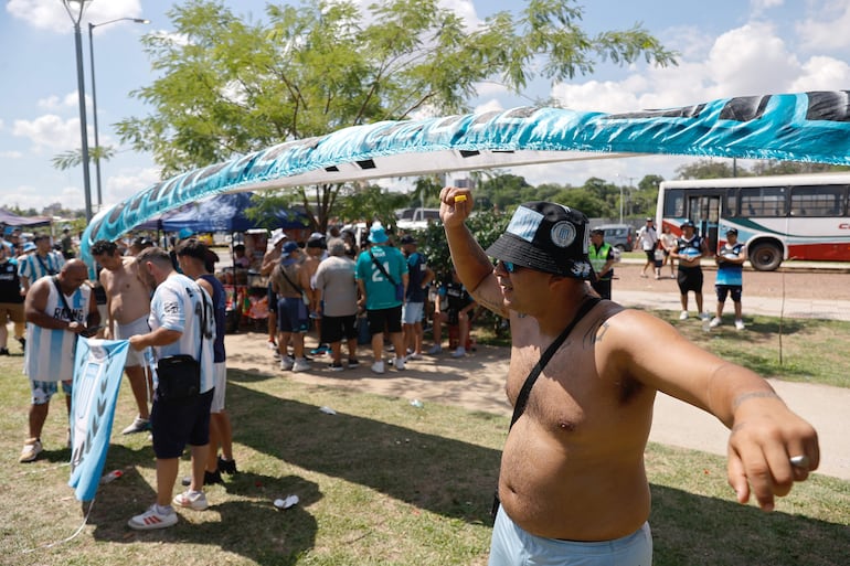 AME255. ASUNCIÓN (PARAGUAY), 23/11/2024.- Aficionados del Club Racing de Argentina, llegan para animar a su equipo este sábado en la Costanera Norte de Asunción (Paraguay). Racing y Cruzeiro buscarán en Asunción su primera Copa Sudamericana, un trofeo que ha sido esquivo para estos viejos rivales en torneos continentales y que llegan a la final de la mano de estrellas como el colombiano Juan Fernando Quintero y la promesa brasileña Kaio Jorge. EFE/Juan Pablo Pino
