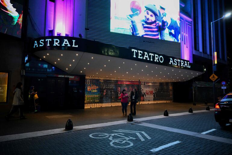 Personas caminan frente al teatro Astral de Buenos Aires.